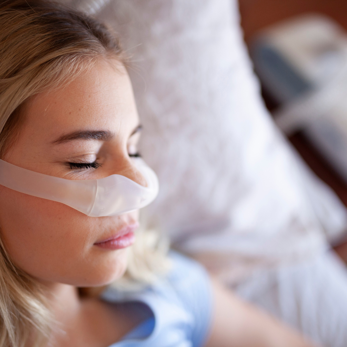 Young girl sleeping while wearing a C-PAP machine