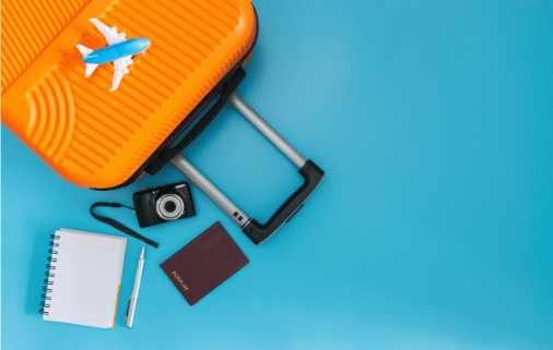 A suitcase featuring an airplane decal, a notebook, camera and passport